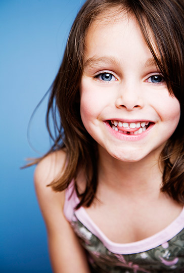 A smiling little girl who is smiling happily. Our Naperville family dentistry practice is happy to provide dental services for your children!